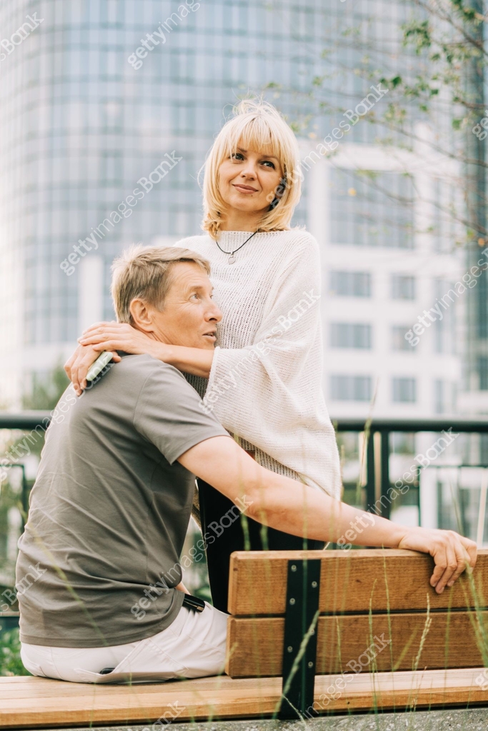 An Adult Mature Happy Romantic Couple In Love Sitting On Bench Outdoors an-adult-mature-happy-romantic-couple-in-love-sitting-on-bench-outdoors