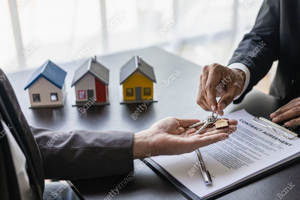 Agent giving client new house key in office The happy man has received ...