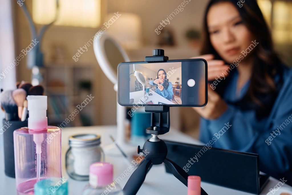 Close up of Asian makeup artist using smart phone while vlogging about ...
