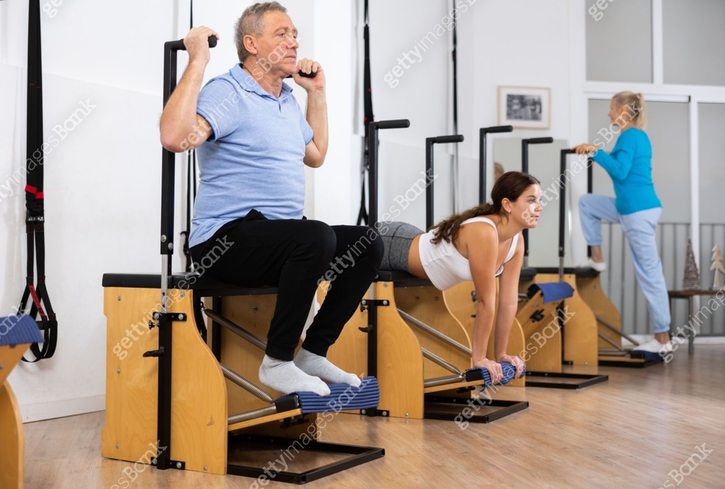 Wanda Stretch Focused mature man performing stretching exercises while using pilates ...