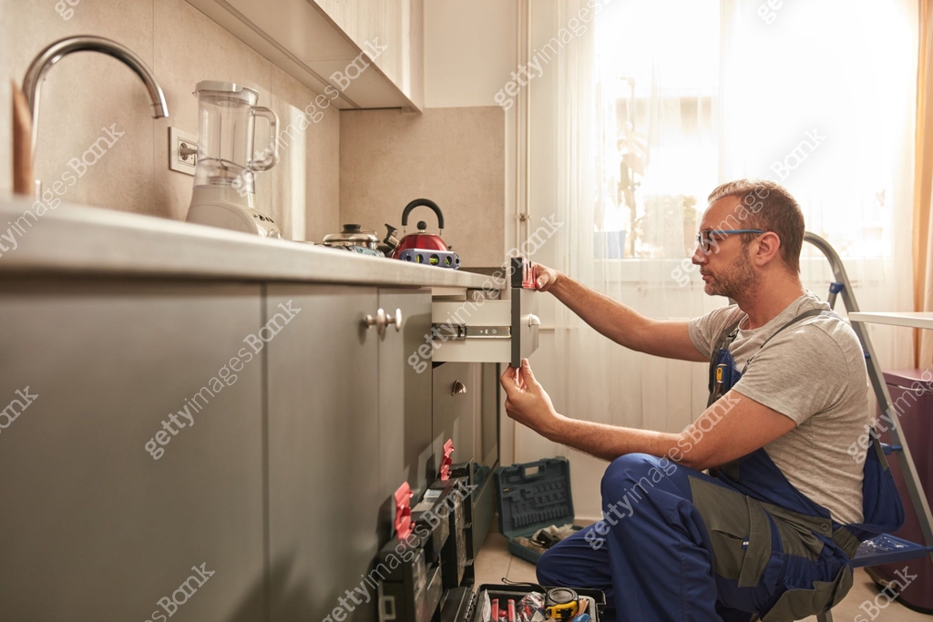 Handyman fixing kitchen cabinets in the apartment. 이미지 (1502937236 ...