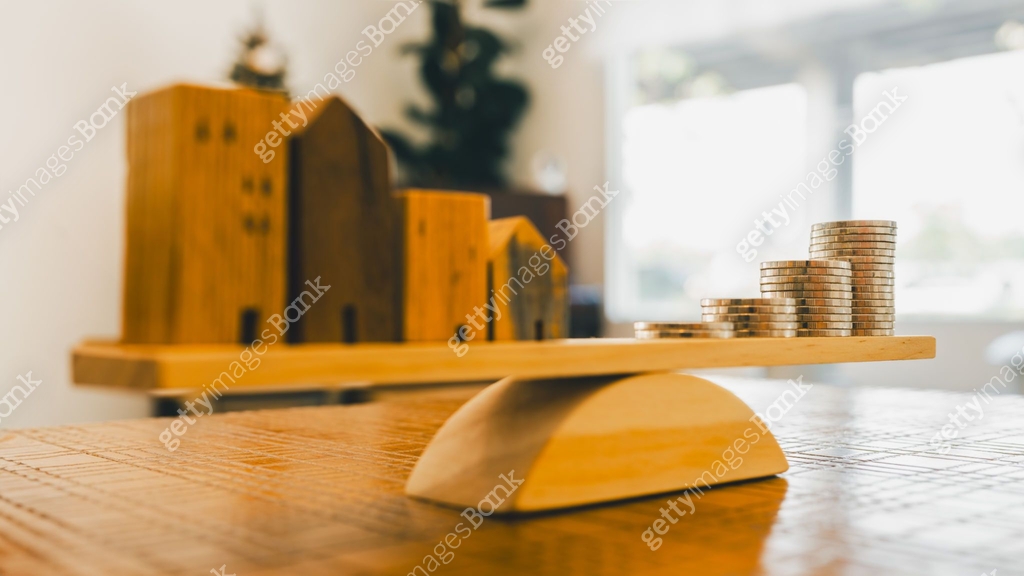 Wood house and Coins stack with balance scale. Money management ...