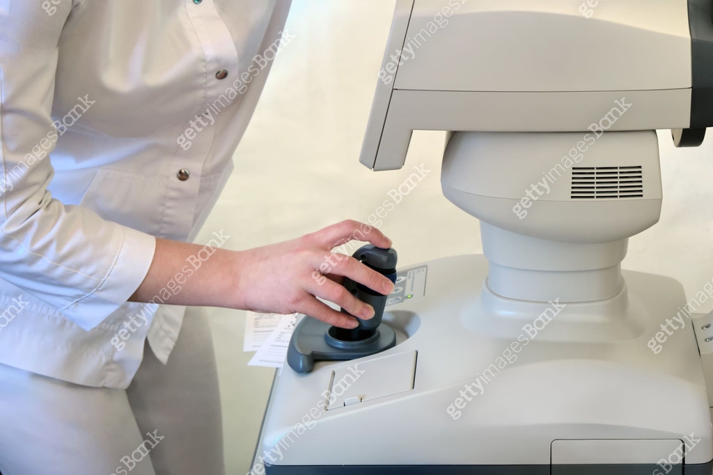 A female ophthalmologist doctor takes measurements of visual acuity on ...
