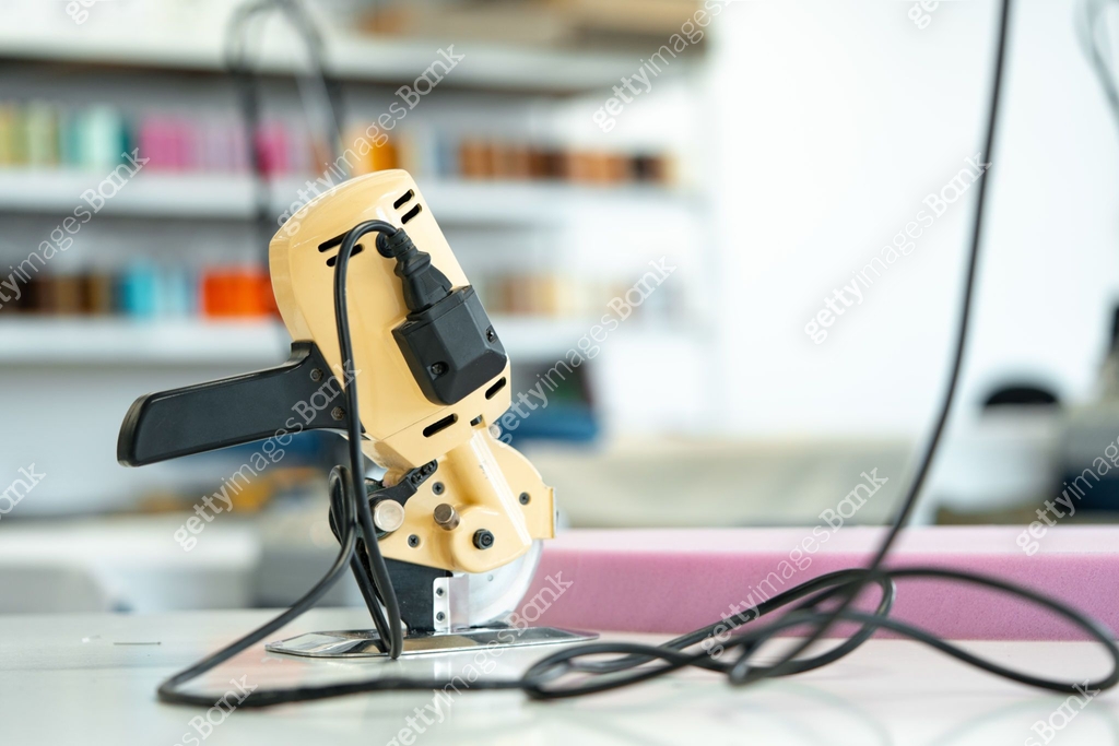 Electric cutting fabric machine on workbench in sewing factory 이미지 ...