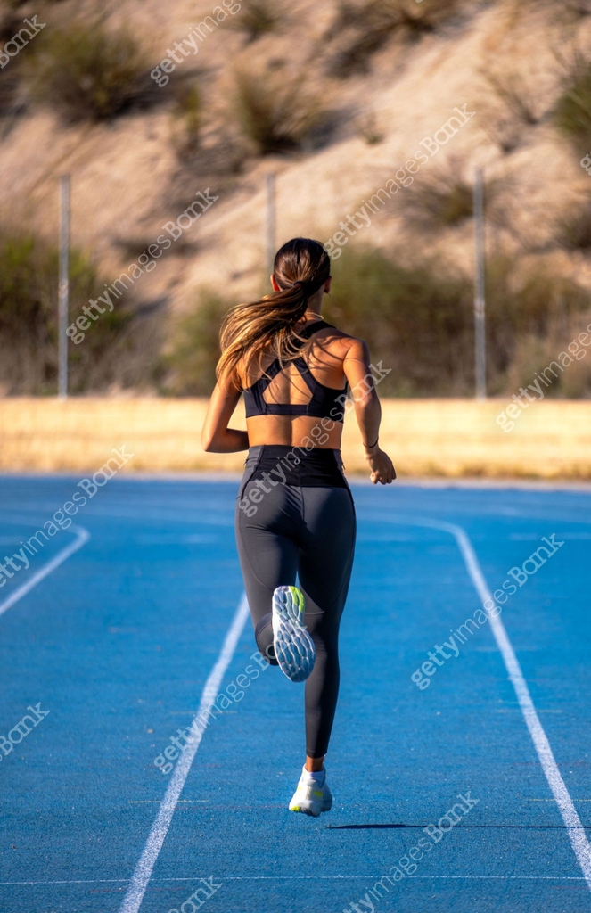 Beautiful tanned slim young runner girl, dressed in tight sportswear ...