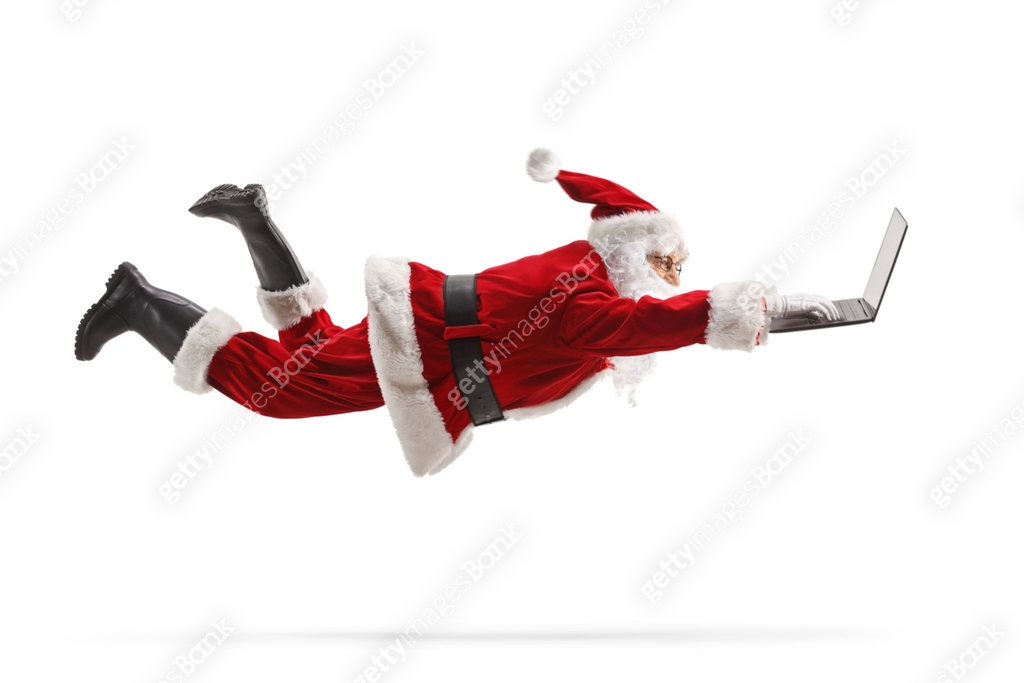 Santa claus flaying and using a laptop computer 이미지 (1738090977) - 게티이미지뱅크