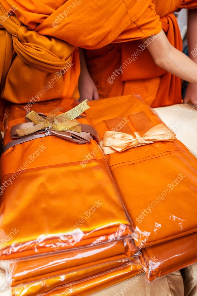 Give a suit or clothes of yellow robes of a Buddhist monk. Thai culture ...