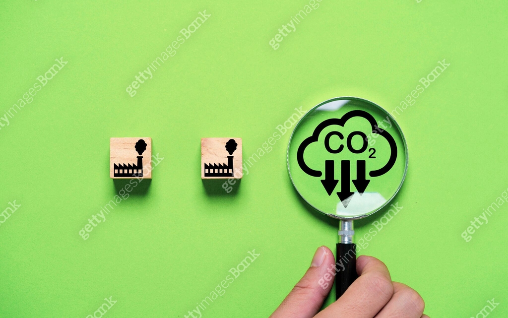 premium photo | hand holding co2 reducing virtual icon... Hand holding magnifier glass with CO2 reducing icon and black factory ...