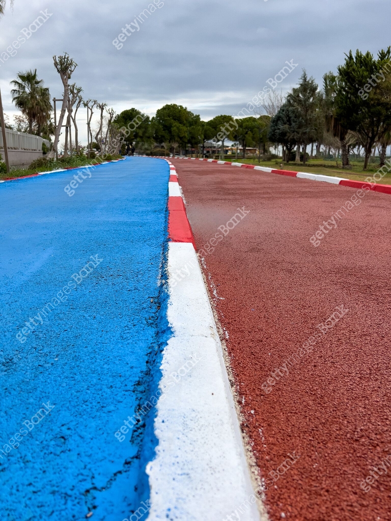 Path Ran Blue bike path and red running path run side by side through a public ...