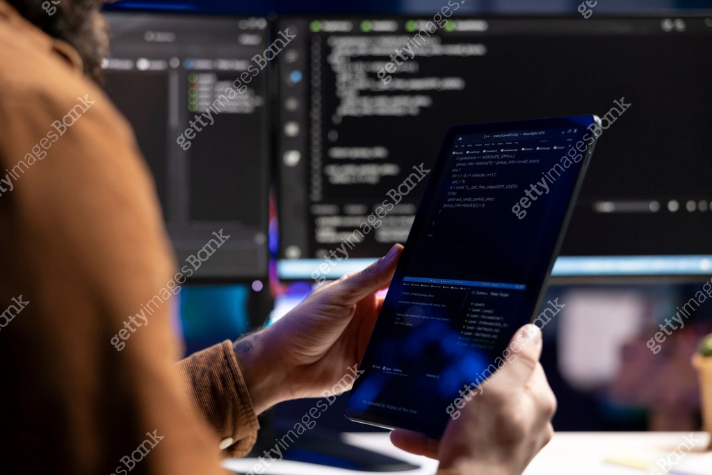 Developer inspecting coding on portable device, looking to fix ...