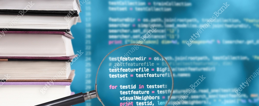 Stack of books, source code and magnifying glass on a blurred ...