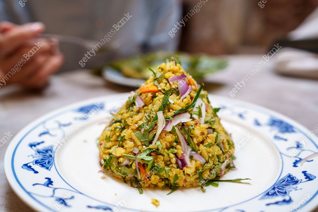 In a cropped image, a woman is seen enjoying Nasi Ulam, a traditional ...