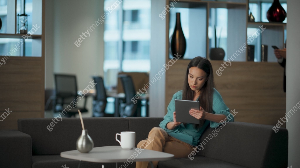 Serious woman reading tablet email at open space. Director lady typing ...