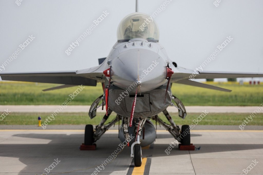 Fighter jet in parking position with red remove before flight ribbon ...