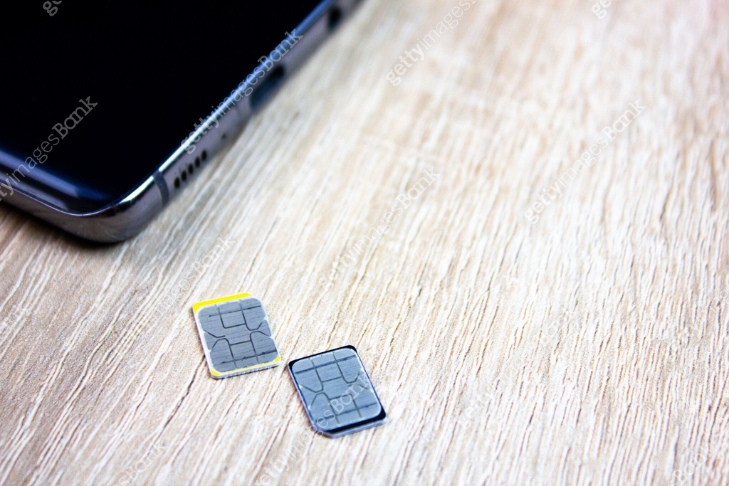 2 sim card next to the smartphone on the table. SIM card cellular ...