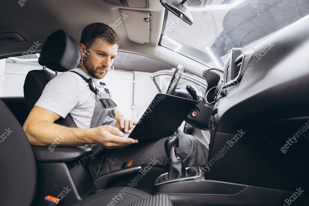 Automotive mechanic running diagnostics software on computer. Mechanic ...
