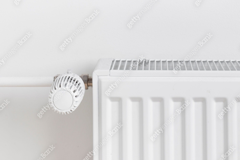 A close-up of a radiator with a temperature control dial mounted on a ...