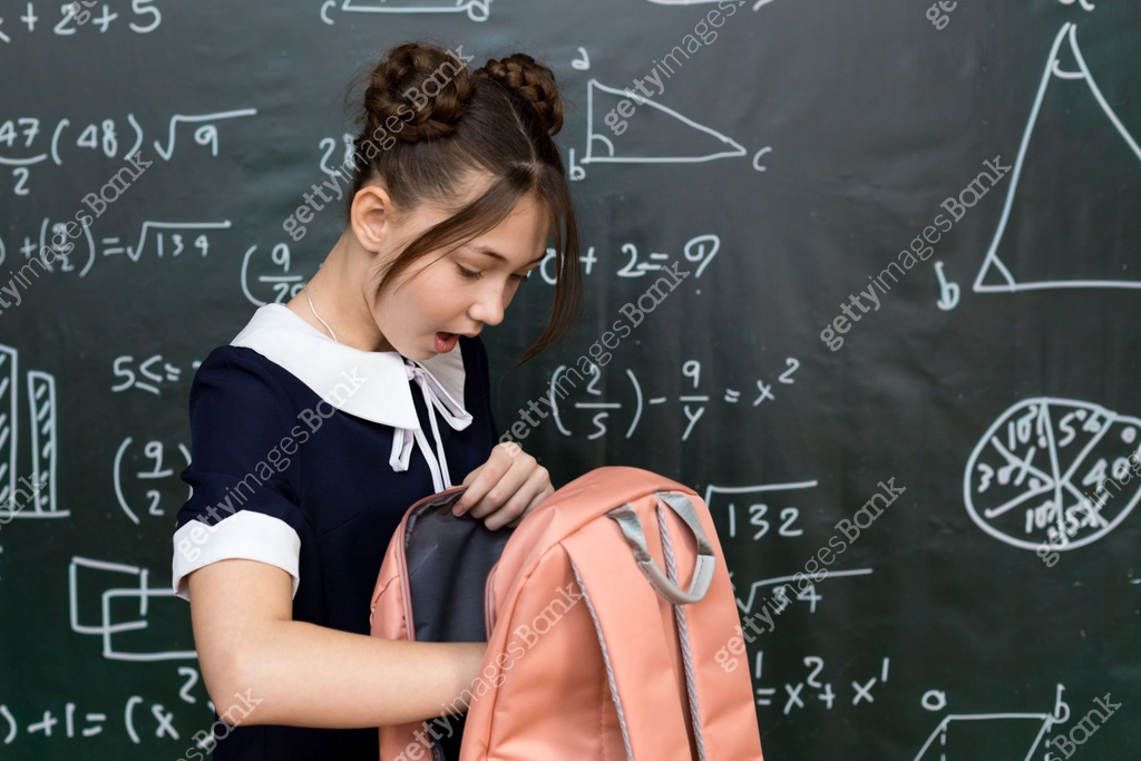 Excited schoolgirl eagerly rummaging through her colorful backpack ...