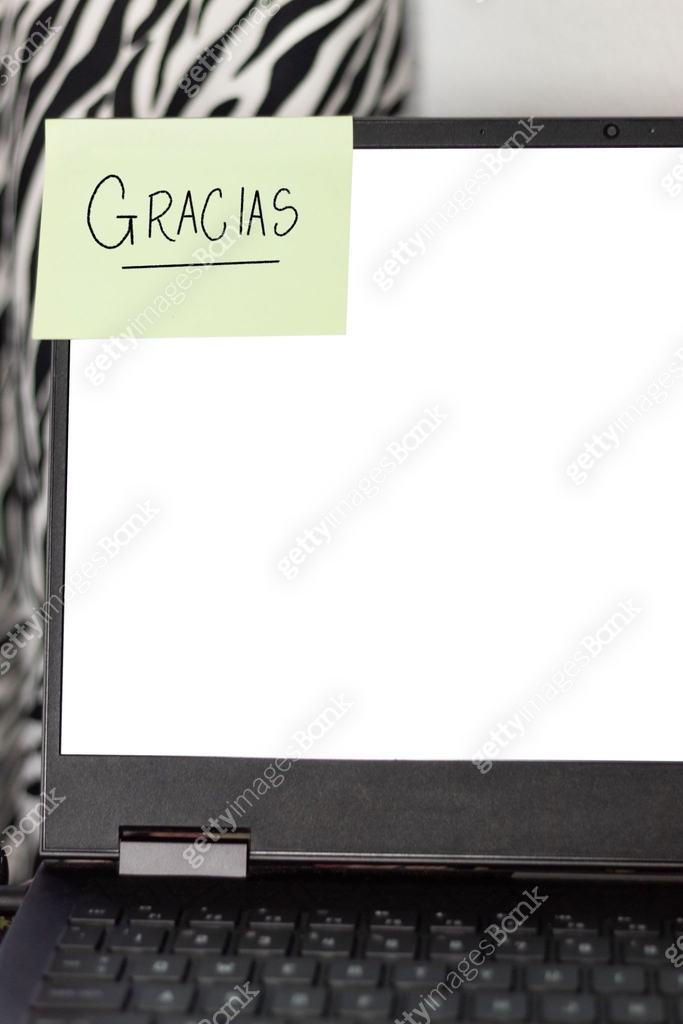 Gratitude message in Spanish written in sticky note on laptop, with ...