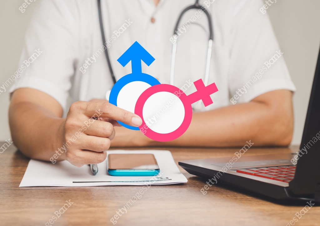 Doctor holding gender symbols representing male and female in medical ...