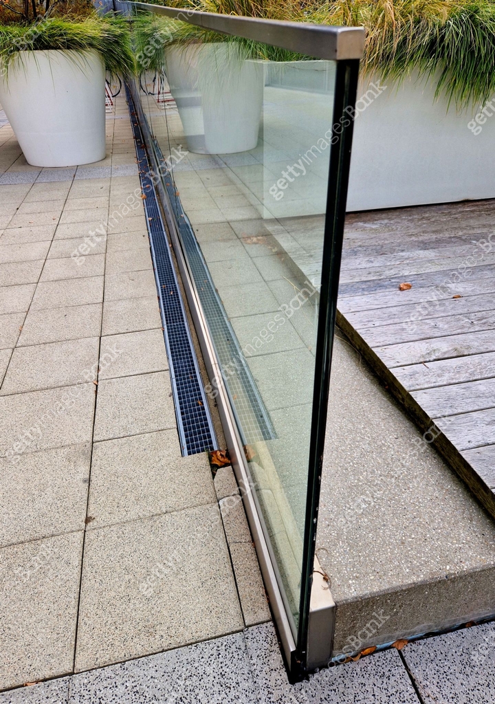 edge of the glued glass of the railing covered by a U-shaped strip ...