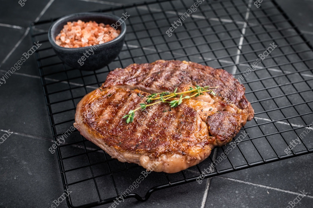 Grilled Rib eye steak on black rack, roasterd prime dry aged beef meat ...
