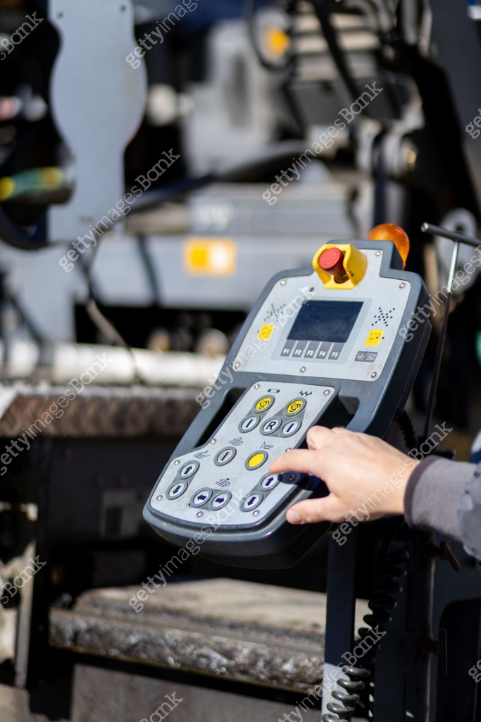 Operator using remote control for machinery in construction zone during ...