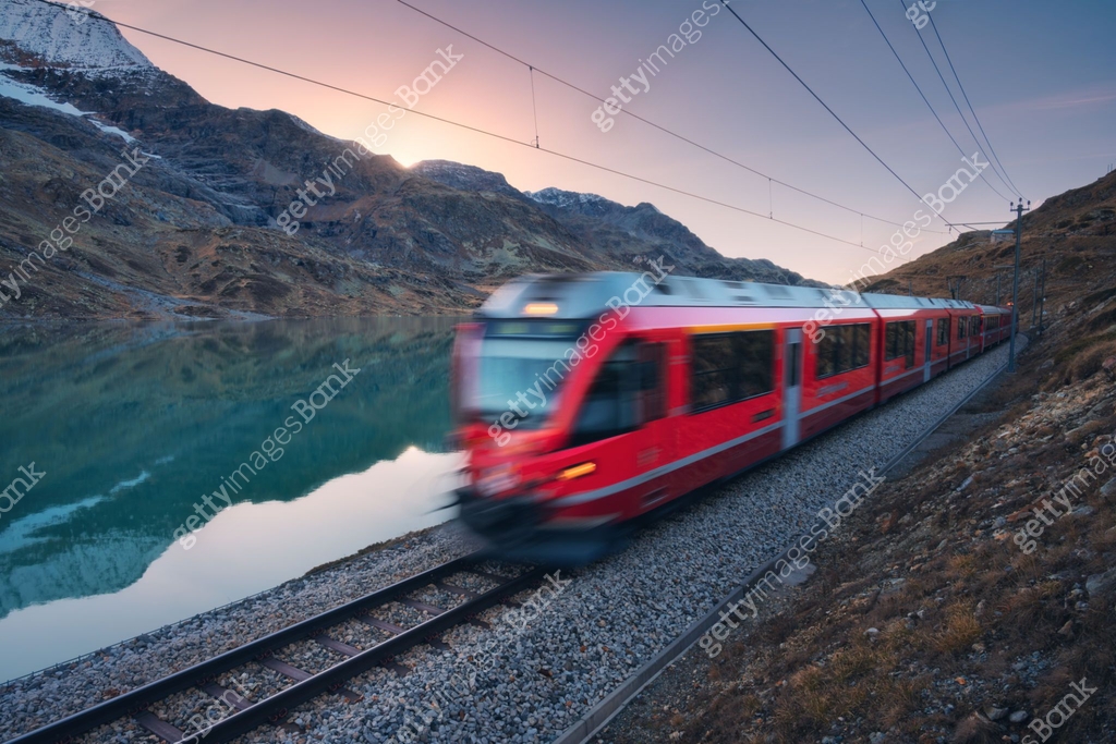 Azure Train Line Moving modern red train near azure mountain Bianco lake, snowy rocks ...